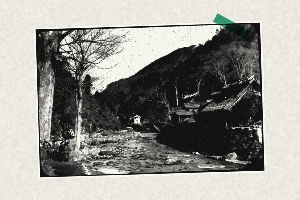 Illustration: River in mountains; raised bank with houses on one side; Japanese children on side of river., from a period photograph (1915), redrawn as a photocopied cutting.